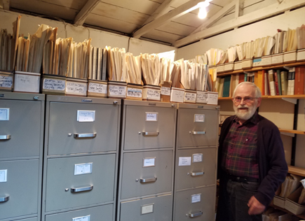 Dr. Jim Matisoff standing with his language materials