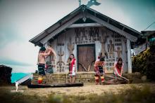 four people standing outside a Poumai Naga house